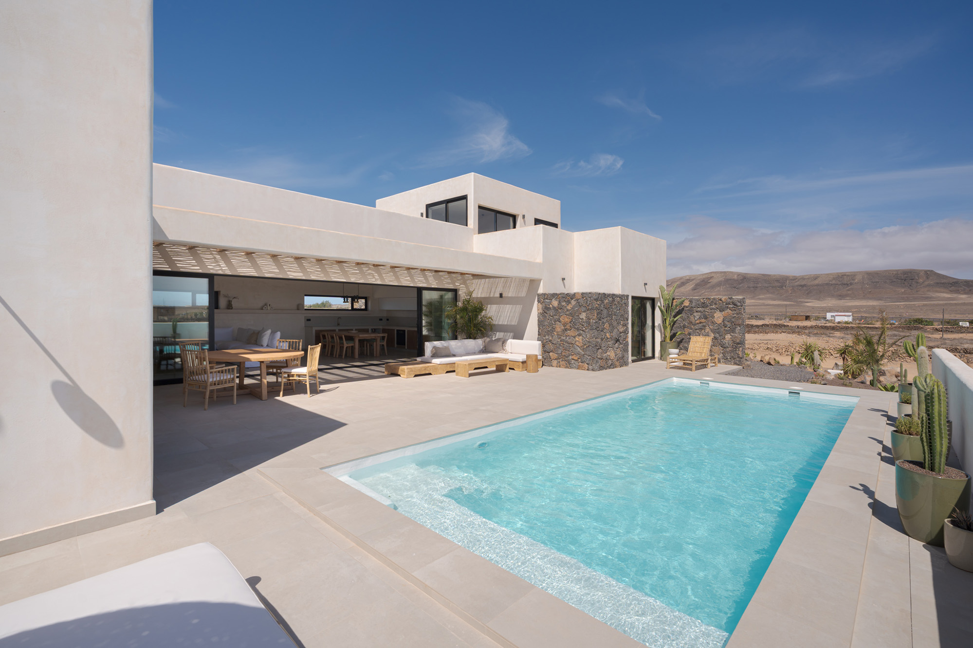Pool terrace with villa architecture and mountain backdrop